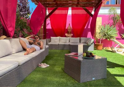 a group of lounge chairs and umbrellas next to a building at Casa Concha - Peaceful and Relaxing in Lagos