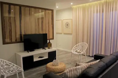 a living room with a couch and a flat screen tv at Casa das Andorinhas in Estreito da Calheta