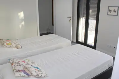 two white beds in a room with a window at Casa das Andorinhas in Estreito da Calheta