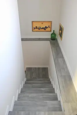 a staircase in a house with a green vase at Casa das Andorinhas in Estreito da Calheta
