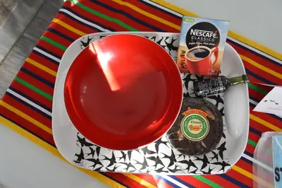a plate with a cup of coffee and a cookie at Casa das Andorinhas in Estreito da Calheta