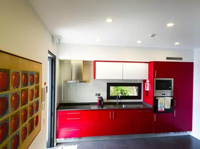 a kitchen with red cabinets and a sink at Casa das Andorinhas in Estreito da Calheta