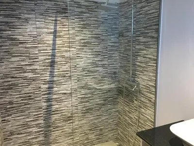 a bathroom with a shower with a glass door at Villa Pinheira II in Estreito da Calheta