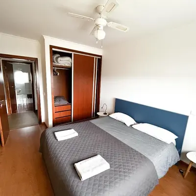 a bedroom with a bed with two towels on it at Cozy Rooms Vila do bispo in Vila do Bispo