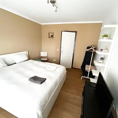 a bedroom with a bed and a flat screen tv at Cozy Rooms Vila do bispo in Vila do Bispo