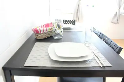 a black table with a white plate on top of it at Cozy Rooms Vila do bispo in Vila do Bispo