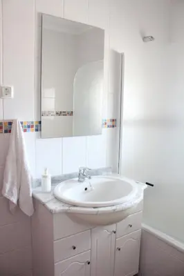 a white bathroom with a sink and a mirror at Cozy Rooms Vila do bispo in Vila do Bispo