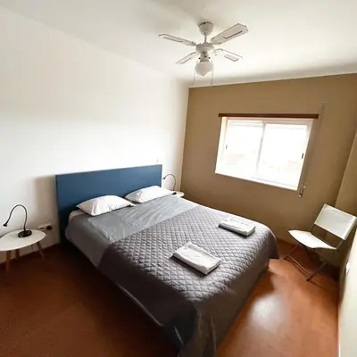 a bedroom with a bed with two towels on it at Cozy Rooms Vila do bispo in Vila do Bispo