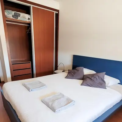 a bedroom with a bed with two towels on it at Cozy Rooms Vila do bispo in Vila do Bispo