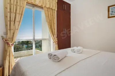 a bedroom with a bed and a large window at Seaview Apartment H in Luz