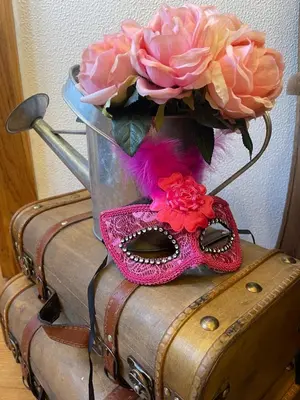 a vase with a mask and flowers on top of a suitcase at Casa dos Avos in Calheta