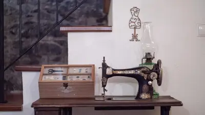 an old sewing machine sitting on a table with a box at Casa dos Avos in Calheta