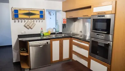 a kitchen with a sink and a stove top oven at Casa dos Avos in Calheta