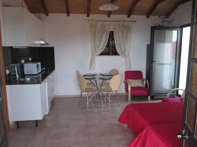 a kitchen and dining room with a table and chairs at Beachfront House Atalaia in Caniço