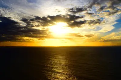 a sunset over the ocean with the sun at Beachfront House Atalaia in Caniço
