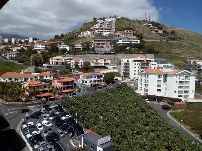 a city with cars parked on a hill with houses at Apartamentos América - Blue Sea in Funchal