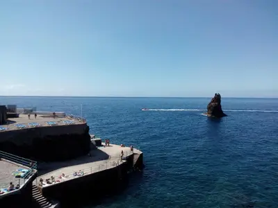 a rock in the water near a beach at Apartamentos América - Blue Sea in Funchal