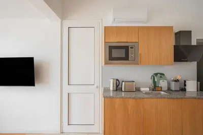 a kitchen with white cabinets and a black appliance at Funchal High View in Funchal