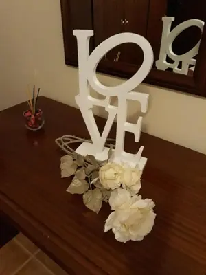 a table with white flowers and a white sign at Apartamento Arrifes in Porto Santo