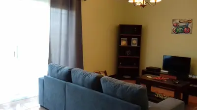 a living room with a blue couch and a table at Apartamento Arrifes in Porto Santo