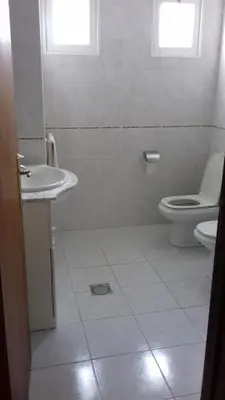 a white bathroom with a toilet and a sink at Apartamento Arrifes in Porto Santo