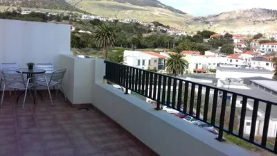 a balcony of a house with a table and chairs at Apartamento Arrifes in Porto Santo