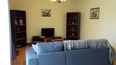 a living room with a blue couch and a tv at Apartamento Arrifes in Porto Santo