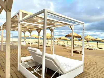 a beach with white lounge chairs and umbrellas at Paradise Beach in Porto Santo