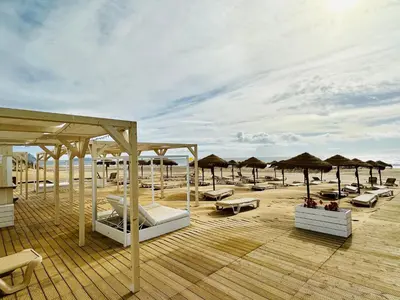 a deck with lounge chairs and umbrellas on the beach at Paradise Beach in Porto Santo