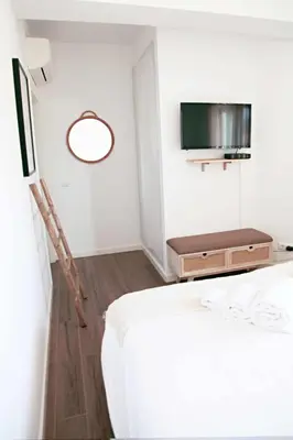 a hotel room with a bed and a tv at Casa Biota in Sagres