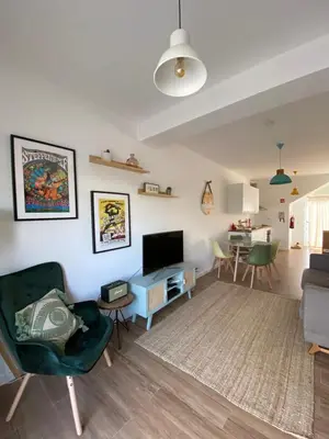 a living room with a couch and a tv and a table at Casa Biota in Sagres