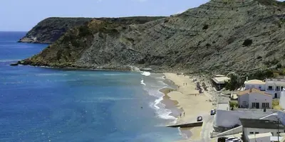 a view of a beach next to the ocean at Apartamentos Os Descobrimentos in Burgau