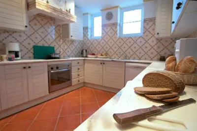 a kitchen with a counter with bread and a knife at Apartamentos Os Descobrimentos in Burgau
