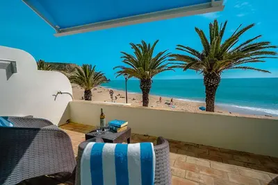 a room with a view of the beach and palm trees at Luz Beach Apartments in Luz