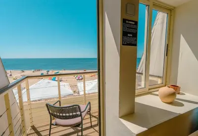 a balcony with two chairs and a view of the beach at Luz Beach Apartments in Luz