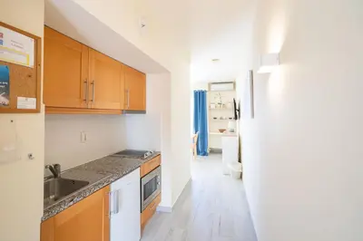a kitchen with wooden cabinets and a sink at Luz Beach Apartments in Luz