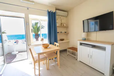 a living room with a table and a television at Luz Beach Apartments in Luz