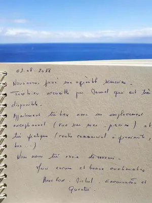 a handwritten letter on the beach with the ocean in the background at Oceanfront Apartment in Funchal