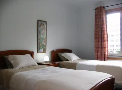 a hotel room with two beds and a window at Oceanfront Apartment in Funchal