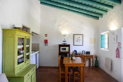 a kitchen and dining room with a table and chairs at Aldeia da Pedralva by WOT Signature in Vila do Bispo