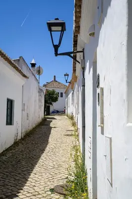 an alley with white buildings and a street light at Aldeia da Pedralva by WOT Signature in Vila do Bispo