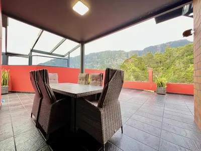 a table and chairs on a balcony with a view at Casa Saramago by AnaLodges in São Vicente