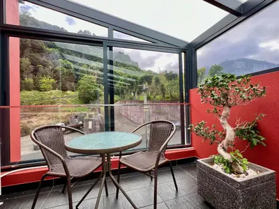 a table and chairs in a room with a window at Casa Saramago by AnaLodges in São Vicente