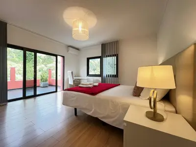 a bedroom with a large bed and a table with a lamp at Casa Saramago by AnaLodges in São Vicente