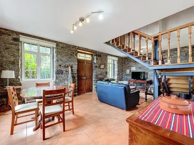 a living room with a staircase and a table and chairs at Quinta do Serrado in Porto Moniz