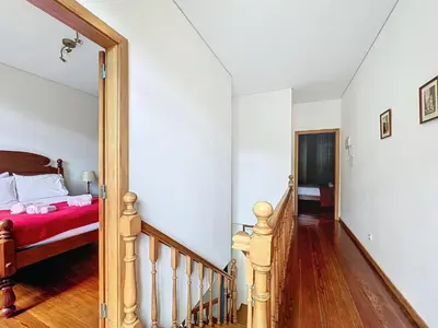 a bedroom with a bed and a staircase with a red blanket at Quinta do Serrado in Porto Moniz