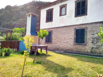 a house with a garden in front of it at Quinta do Serrado in Porto Moniz