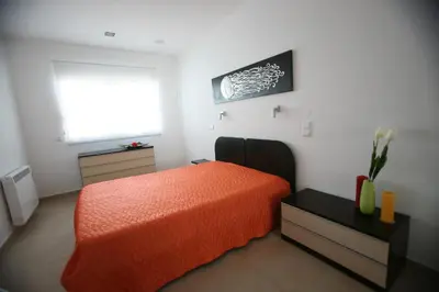 a bedroom with an orange bed and a window at Luz House in Luz
