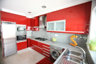a red kitchen with a sink and a dishwasher at Luz House in Luz