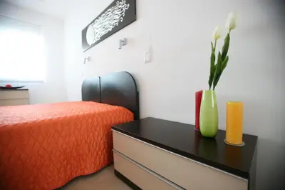 a bedroom with a bed and a vase with flowers on a table at Luz House in Luz